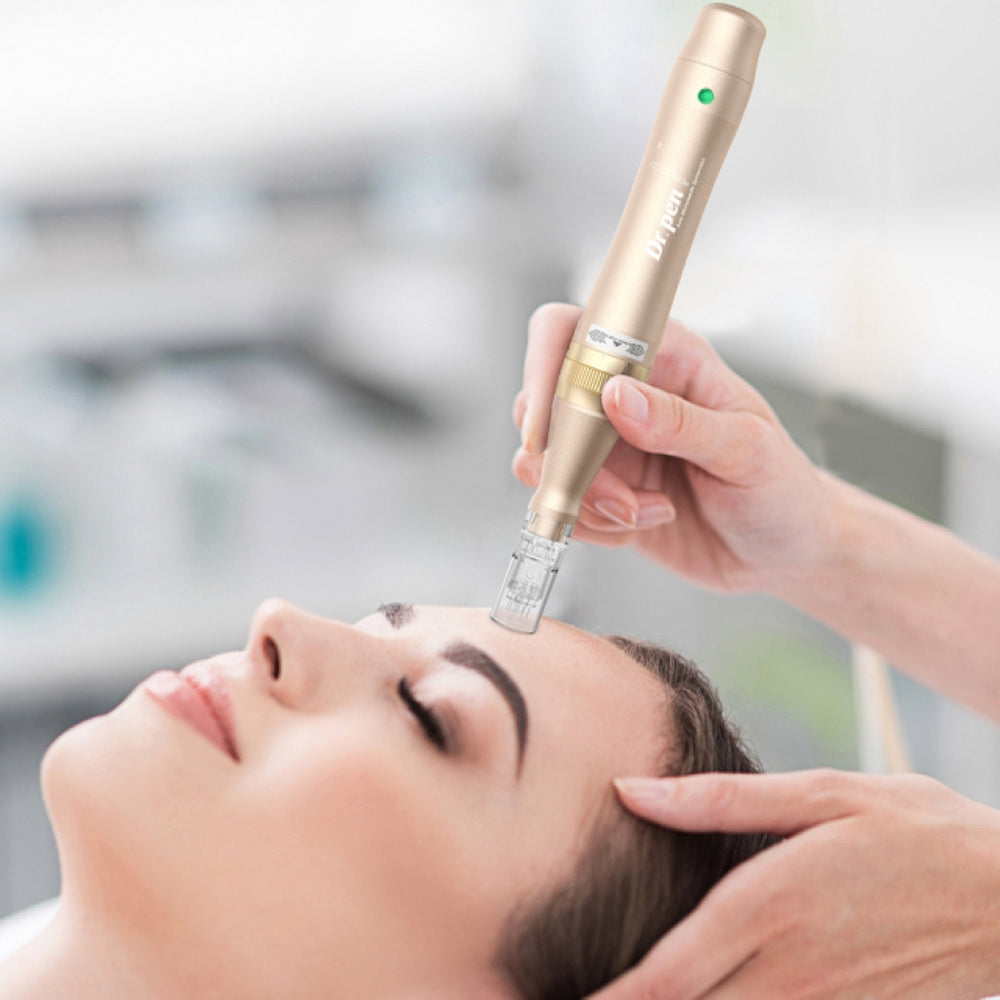 Een persoon ligt ontspannen terwijl een behandelaar microneedling op het voorhoofd uitvoert met een goudkleurige Dr. Pen M5. De behandelaar houdt de pen met beide handen voor precisie.