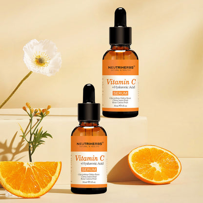 Neutriherbs Vitamin C + Hyaluronic Acid Serum 30 ml samen met verse sinaasappels en bloemen. Inspirerende productafbeelding die het gehalte aan vitamine C van het serum benadrukt voor een gehydrateerde huid, meer glans en een egalere teint.